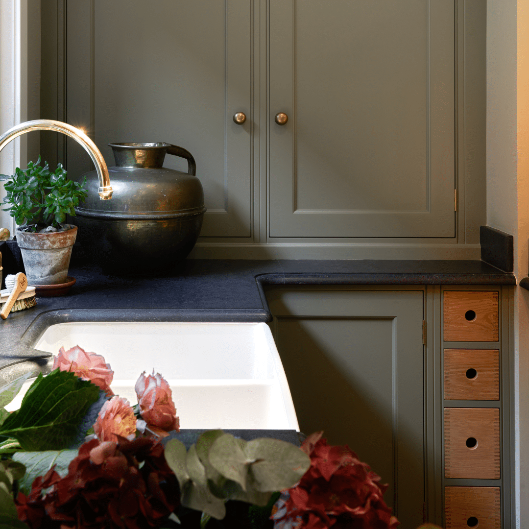 Flowers by Belfast sink and Perrin and Rowe tap with green painted Faroow and Ball kitchen cabinet.